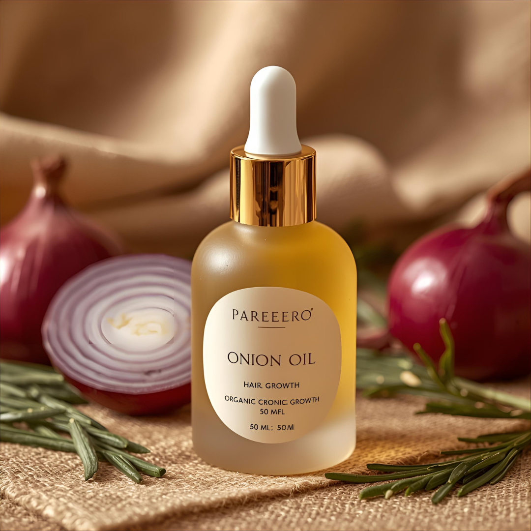 Pareero Onion Oil bottle surrounded by fresh red onions and green herbs โ organic hair oil for strong and healthy hair