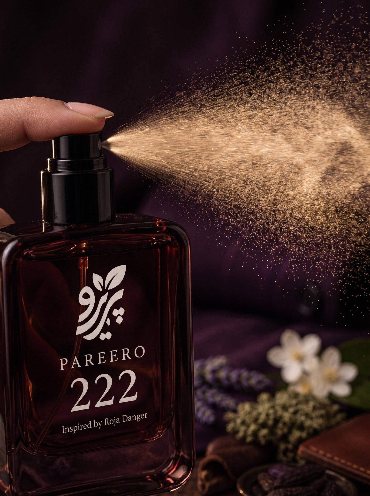Pareero 222 inspired by Roja Danger spraying a fine fragrance mist against a deep plum luxury background