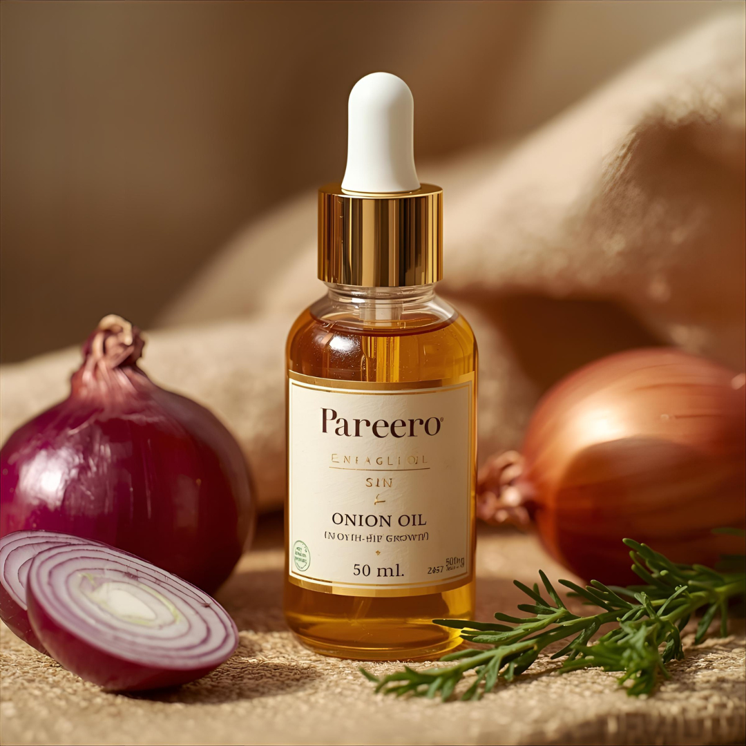 Pareero Onion Oil bottle surrounded by fresh red onions and green herbs – organic hair oil for strong and healthy hair