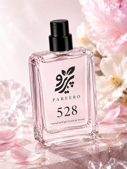 Angled PAREERO 528 fragrance bottle surrounded by soft pink and white flowers with crystal light