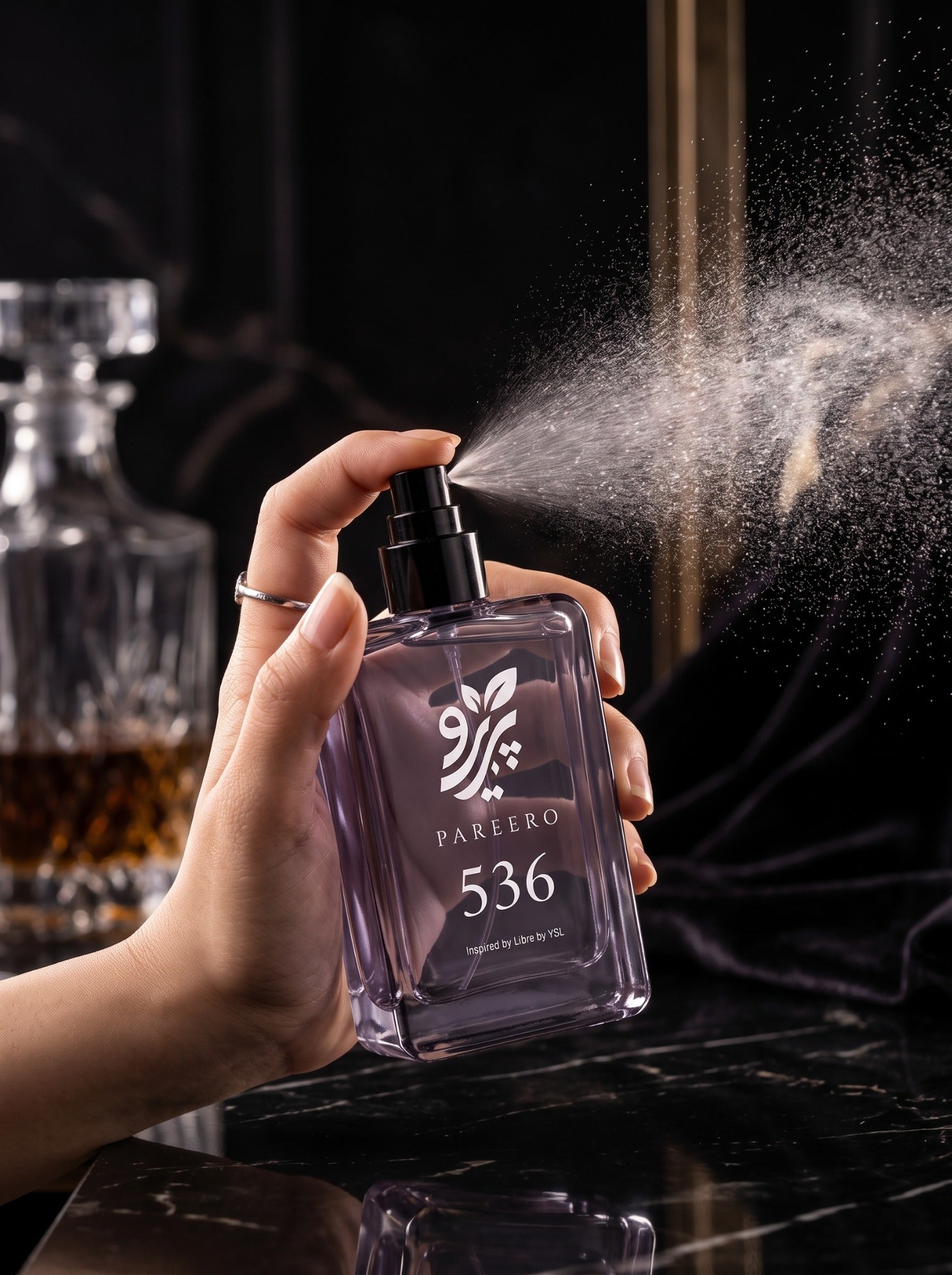 PAREERO 536 Libre-inspired fragrance being sprayed in a dramatic evening setting