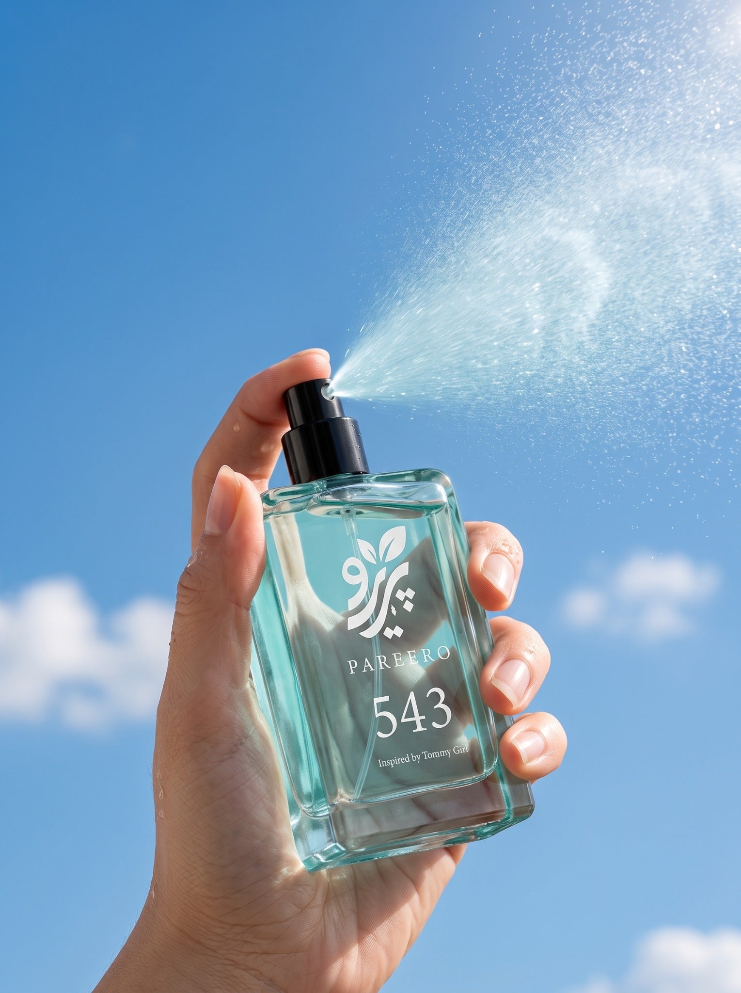 Hand spraying PAREERO 543 Tommy Girl-inspired fragrance against a bright blue sky