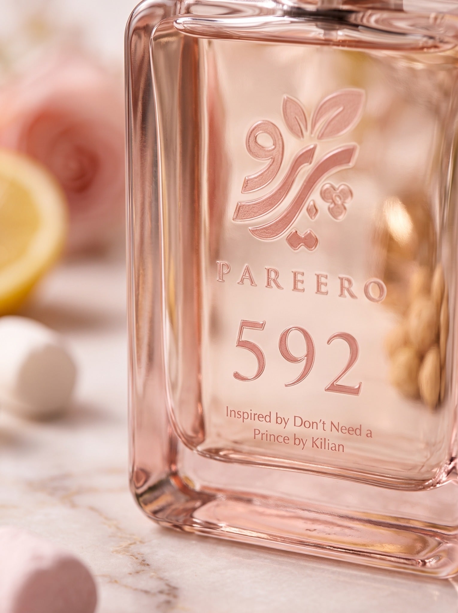 Macro view of the rose-toned PAREERO 592 logo, typography and glass bottle