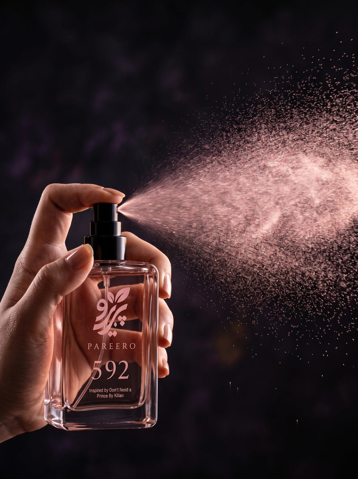Hand spraying PAREERO 592 fragrance in a dramatic dark rose-toned setting