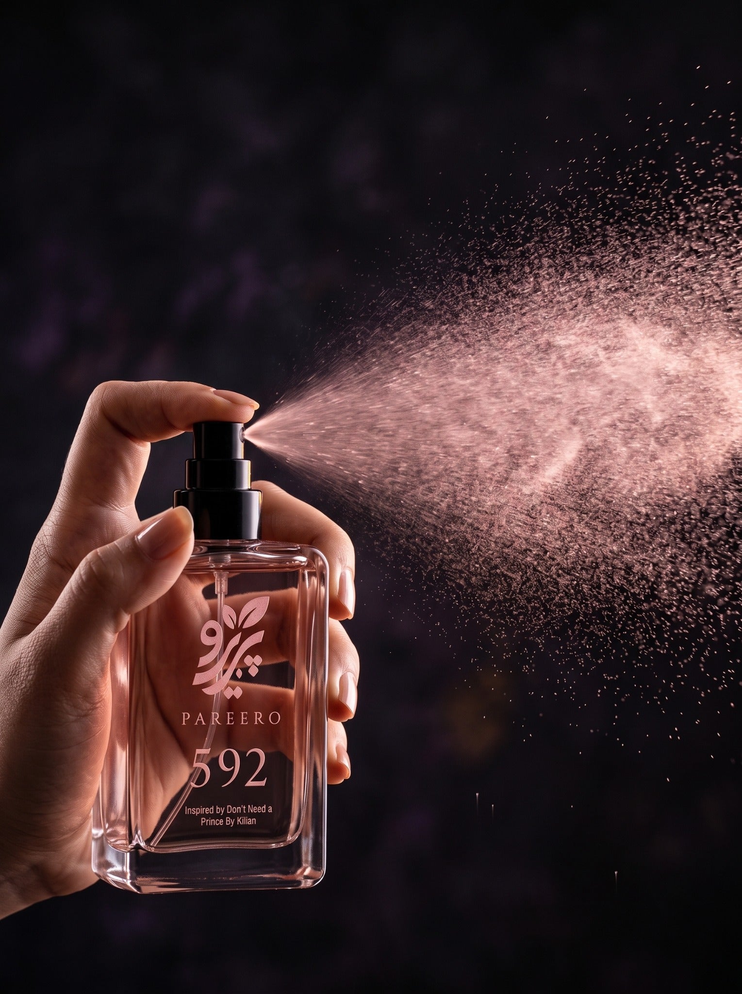 Hand spraying PAREERO 592 fragrance in a dramatic dark rose-toned setting